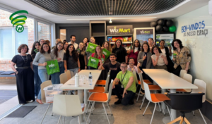 Colaboradores reunidos em espaço corporativo com minimercado WizMart, durante ação de inauguração e convivência no escritório.